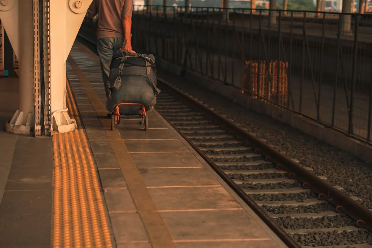 Traveler with luggage waiting at a train platform