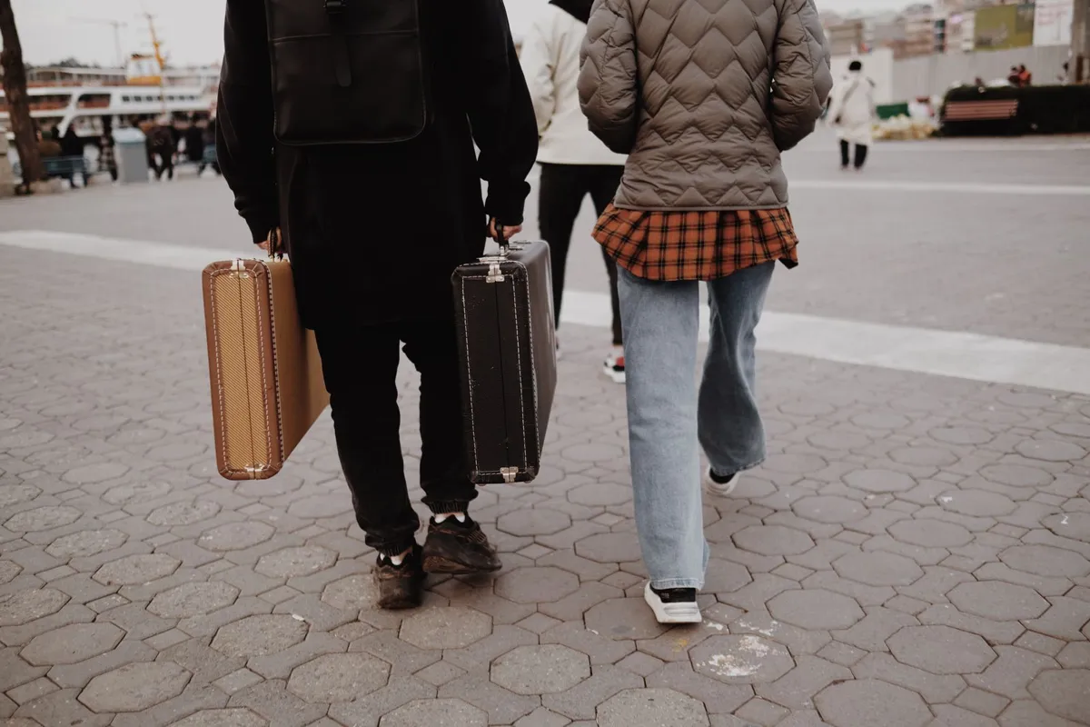 Travelers carrying suitcases on a city walk