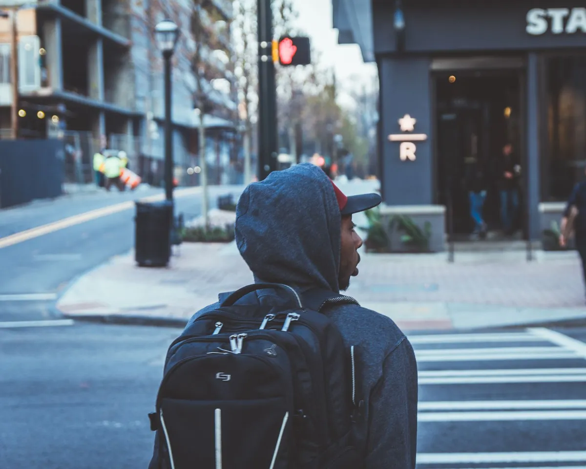 A city walker wearing a compact black backpack