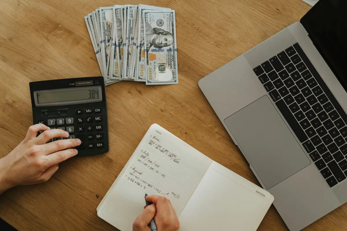 Calculator, notebook and cash on a planning table