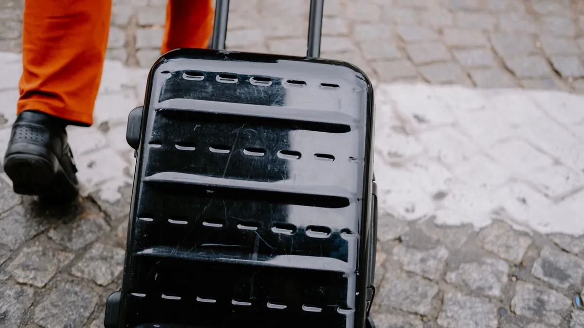 Wheeled suitcase pulled across cobblestones