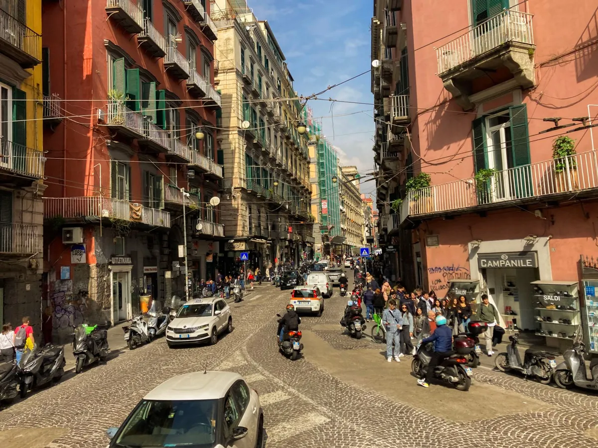 A lively street among historic buildings in Naples