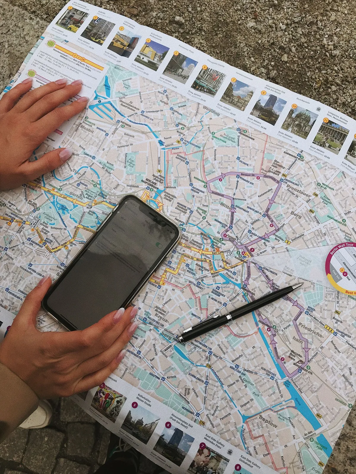 A smartphone and pen resting on a paper city map