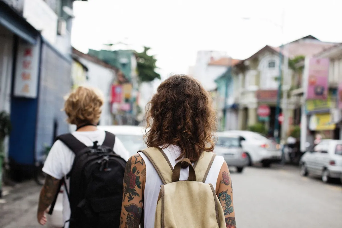 Travelers with backpacks walking along a city street